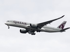 FILE - A Qatar Airways jet approaches Philadelphia International Airport in Philadelphia, Nov. 7, 2019. An Australian court on Wednesday, April 10, 2024, has rejected a case brought by five women seeking compensation from Qatar Airways over invasive gynecological examinations conducted on passengers at Doha's airport in 2020. The women's case against the airport's operator is still going ahead, however.