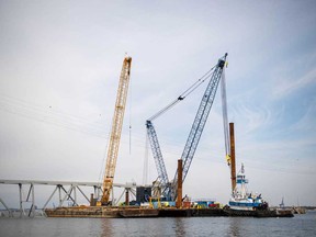 This handout photo obtained from the U.S. Coast Guard on March 31, 2024 shows barge cranes near the collapsed Francis Scott Key Bridge on in the Patapsco River, in Baltimore, Md., March 30, 2024.