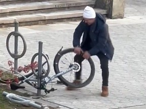 Screenshot of man wrecking bike locked up outside Bader Theatre on University of Toronto campus.