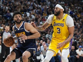 Denver Nuggets guard Jamal Murray, left, drives to the basket as Los Angeles Lakers forward Anthony Davis, right, defends in the first half of Game 5 of an NBA basketball first-round playoff series Monday, April 29, 2024, in Denver.