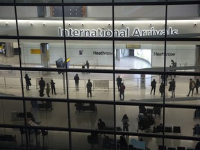People are seen in the arrivals area at Heathrow Airport