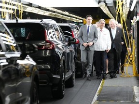 Prime Minister Justin Trudeau (left to right), Honda executive Toshihiro Mibe and Ontario Premier Doug Ford walk along an assembly line at an event announcing plans for a Honda electric vehicle battery plant in Alliston, Ont. on Thursday, April 25, 2024.