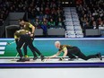 Manitoba-Carruthers skip Brad Jacobs, right, delivers a rock as second Derek Samagalski, back left, and lead Connor Njegovan, front left, sweep while playing Team Manitoba-Dunstone during the playoffs at the Brier, in Regina, March 8, 2024. Jennifer Jones and Brad Jacobs bounced back from lopsided tournament-opening losses with victories in Wednesday's early draw at the Grand Slam of Curling's Players' Championship.