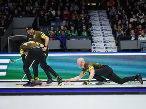 Manitoba-Carruthers skip Brad Jacobs, right, delivers a rock as second Derek Samagalski, back left, and lead Connor Njegovan, front left, sweep while playing Team Manitoba-Dunstone during the playoffs at the Brier, in Regina, March 8, 2024. Jennifer Jones and Brad Jacobs bounced back from lopsided tournament-opening losses with victories in Wednesday's early draw at the Grand Slam of Curling's Players' Championship.