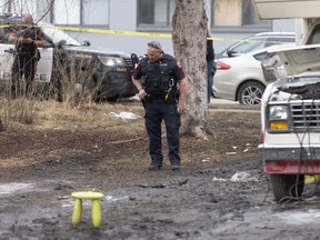Law enforcement work outside a motorhome at a reported encampment near Macleod Trail, where a dog that bit a police officer was shot dead on Tuesday, April 2, 2024.