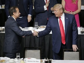 FILE - President Donald Trump, right, shakes hands with John Paulson during a meeting of the Economic Club of New York in New York, Nov. 12, 2019. Trump's campaign is expecting to raise more than $40 million on Saturday, April 6, 2024, when a group of major donors gather at Paulson's Palm Beach, Fla. home for Trump's biggest fundraiser yet as his third White House campaign drastically ramps up fundraising.