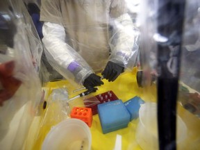 A lab technician works in a mobile lab at the National Microbiology Lab in Winnipeg on Nov. 3, 2014.