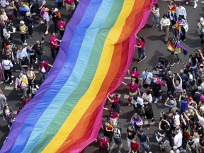 People hold a rainbow flag as they attend the 45th Berlin Pride Parade for Christopher Street Day (CSD) in Berlin, Germany, Saturday, July 22, 2023.