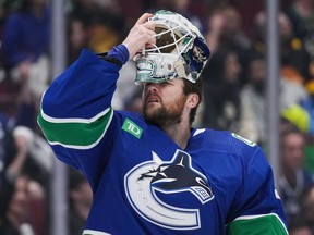 Vancouver Canucks goalie Thatcher Demko puts his mask back on after it was struck by a puck during the second period in Game 1 of an NHL hockey Stanley Cup first-round playoff series against the Nashville Predators in Vancouver on Sunday, April 21, 2024.