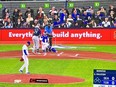 TV showing Blue Jays/Mariners game featuring pitcher, batter and fans behind home plate.