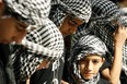 Palestinian youths wearing the traditional checkered keffiyeh attend a rally held in the Palestinian refugee camp of Ain el-Helweh on the outskirts of the southern Lebanese city of Sidon on Nov. 16, 2012, against Israel's military operation in the Gaza Strip.