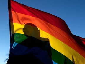 In this file photo taken on Nov. 20, 2022, a community member's silhouette is seen through a Pride flag while paying their respects to the victims of the mass shooting at Club Q, an LGBTQ nightclub, in Colorado Springs, Colorado.