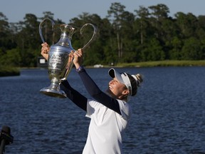 Nelly Korda holds up the trophy while celebrating her win at the Chevron Championship LPGA golf tournament Sunday, April 21, 2024, at The Club at Carlton Woods in The Woodlands, Texas.