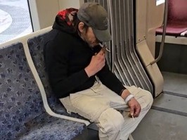 Screenshot of man smoking crack on TTC streetcar.