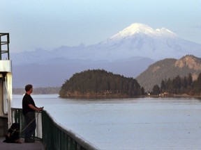 A Washington state ferry passes through a channel in the San Juan Islands and in view of Mount Baker Thursday, March 26, 2015, near Friday Harbor, Washington state.