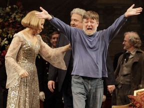 Conductor Andrew Davis, right, raises his arms as he takes a bow, accompanied by Renee Fleming, and Peter Rose, centre, during the final dress rehearsal of Richard Strauss' "Capriccio" in the Metropolitan Opera at New York's Lincoln Center, March 25, 2011.
