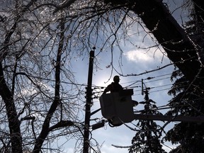 A Toronto Hydro line worker works to restore power to a house in a Scarborough neighbourhood on Friday, December 27, 2013. Officials say two utility workers were sent to hospital after they were injured while working at a Toronto hydro vault.