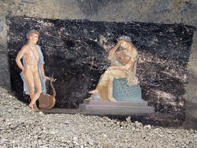 This handout picture released by the archaelogical park of Pompeii on April 11, 2024 shows frescoes depicting mythological characters Appolo and Cassandra, the daughter of Priam, in a banqueting room with black walls part of the ongoing excavations in the block 10 of Regio IX, in Pompeii, near Naples.