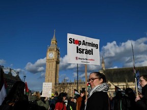 Pro-Palestinian activists and supporters hold placards and chant slogans as they gather in front of The Elizabeth Tower, commonly known by the name of the clock's bell "Big Ben," at the Palace of Westminster, home to the Houses of Parliament, in central London, on April 17, 2024 to protest against the export of arms from Britain to Israel.