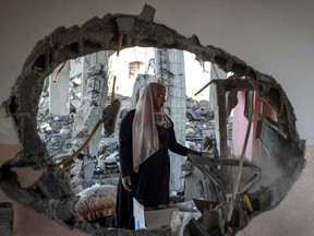 A Palestinian woman checks the rubble of a home hit by overnight Israeli bombing in Rafah in the southern Gaza Strip on April 20, 2024, amid the ongoing conflict between Israel and the Hamas movement.