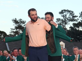 Scottie Scheffler of the United States is awarded the Green Jacket by 2023 Masters champion Jon Rahm of Spain during the Green Jacket Ceremony after Scheffler won the 2024 Masters Tournament at Augusta National Golf Club on April 14, 2024 in Augusta, Ga.