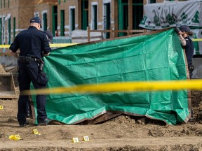A member of the Edmonton Police Service identification team takes pictures at the scene of a shooting that left two people dead at a construction site at Cavanagh Boulevard on Monday, April 8, 2024.