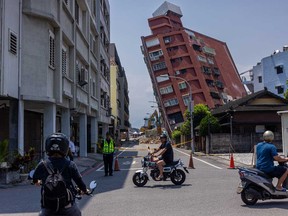 People drive past an area of a damaged building which is cordoned off following the earthquake on April 4, 2024 in Hualien, Taiwan.