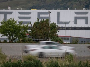 Vehicles pass the Tesla Inc. assembly plant in Fremont, California, U.S., on Monday, May 11, 2020.
