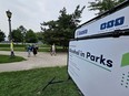 Pedestrians pass a sign from the City of Toronto declaring the temporary legality of consuming alcohol in Trinity-Bellwoods Park, in Toronto, Wednesday, Aug. 2, 2023.