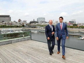 Prime Minister Justin Trudeau and German Chancellor Olaf Scholz turn away after looking out at the skyline in Montreal on Aug. 22, 2022.