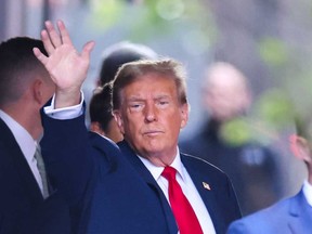 Former U.S. president Donald Trump waves as he departs Trump Tower for Manhattan Criminal Court, to attend the first day of his trial for allegedly covering up hush money payments linked to extramarital affairs, in New York City on April 15, 2024.