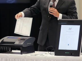 FILE - A Smartmatic representative demonstrates his company's system, which has scanners and touch screens with printout options, at a meeting of the Secure, Accessible & Fair Elections Commission, Aug. 30, 2018, in Grovetown, Ga. The voting technology company targeted by bogus fraud claims related to the 2020 presidential election settled a defamation lawsuit Tuesday, April 16, 2024, against a conservative news outlet.
