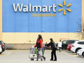 People leave a Walmart store in Mississauga, Ont., Thursday, Nov. 26, 2020.
