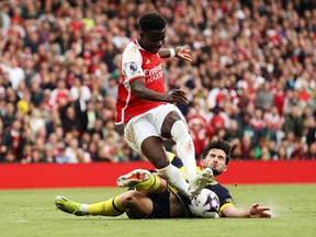Bukayo Saka of Arsenal is tackled by Lewis Cook of AFC Bournemouth.