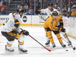 Team MacKinnon's Travis Konecny (11) skates with the puck against Team McDavid's Connor McDavid (97) and Boone Jenner (38) during the NHL all-star game.