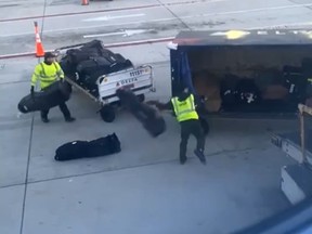 Two Delta Air Lines baggage handlers are seen tossing golf clubs.