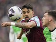 West Ham's Lucas Paqueta, left, and Liverpool's Andrew Robertson battle for the ball.