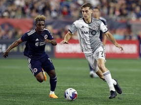 Toronto FC's Jordan Perruzza and New England Revolution's Latif Blessing battle for the ball.