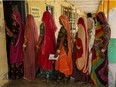 Women stand in a queue outside a polling station
