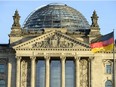 The German national flag is seen in front of the Reichstag building housing the German parliament Bundestag on December 16, 2013.