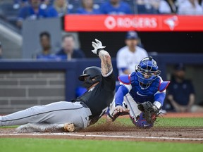Korey Lee of the Chicago White Sox slides in to home ahead of the tag from Blue Jays catcher Danny Jansen during the second inning in Toronto on Tuesday, May 21, 2024.