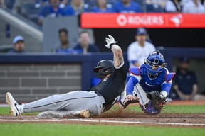 Korey Lee of the Chicago White Sox slides in to home ahead of the tag from Blue Jays catcher Danny Jansen during the second inning in Toronto on Tuesday, May 21, 2024.