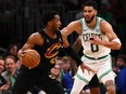 Jayson Tatum of the Boston Celtics defends Donovan Mitchell of the Cleveland Cavaliers during the fourth quarter in Game 2 of the Eastern Conference Second Round Playoffs at TD Garden on May 9, 2024 in Boston.