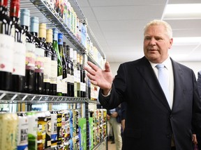 Ontario Premier Doug Ford gestures to a display of alcohol at an announcement saying the province is speeding up the expansion of alcohol sales, in Toronto, Friday, May 24, 2024.