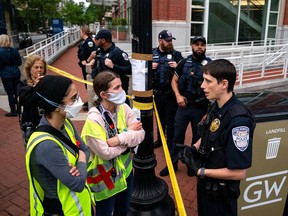 Demonstrators talk to a George Washington University police officer