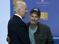 Then-Vice President Joe Biden hugs comedian Jon Stewart during a comedy show organized by United Services Organizations (USO) for members of the military and their families, at Andrews Air Force Base, May 5, 2016, in Joint Base Andrews, Maryland.