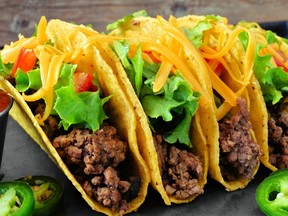 Group of ground beef hard shelled tacos close up