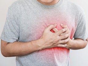 a man touching his heart, with red highlight of heart attack, heart failure and others heart disease