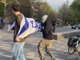 An Israeli flagged is grabbed off a person's back