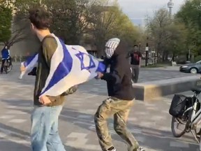An Israeli flagged is grabbed off a person's back